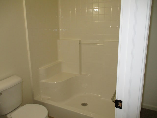 full bathroom featuring a shower and toilet