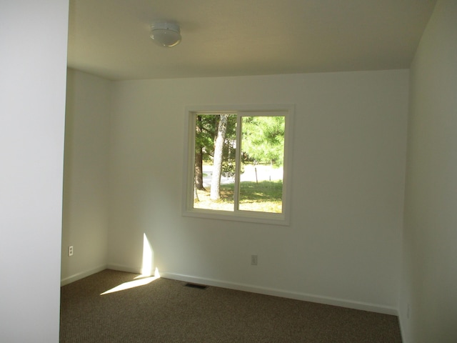 carpeted empty room featuring visible vents and baseboards