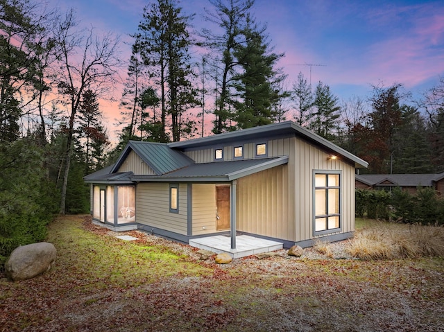 exterior space with board and batten siding and metal roof