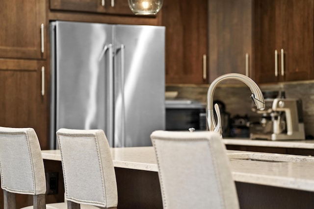 kitchen featuring high quality fridge and tasteful backsplash