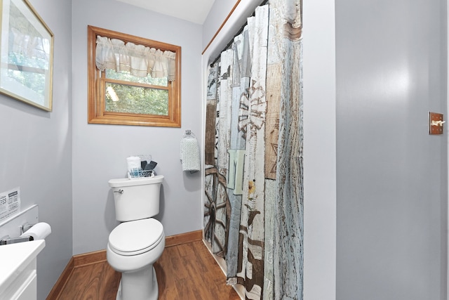 bathroom with vanity, a shower with shower curtain, wood finished floors, baseboards, and toilet