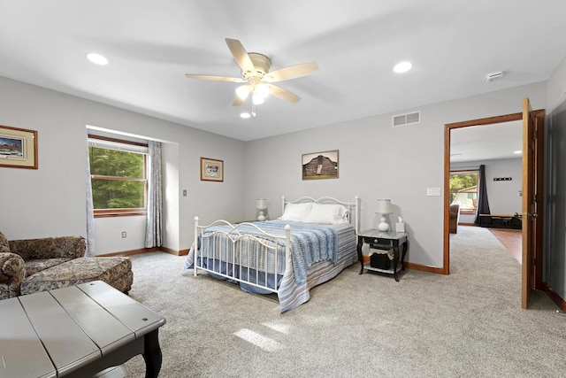 carpeted bedroom with visible vents, multiple windows, and baseboards