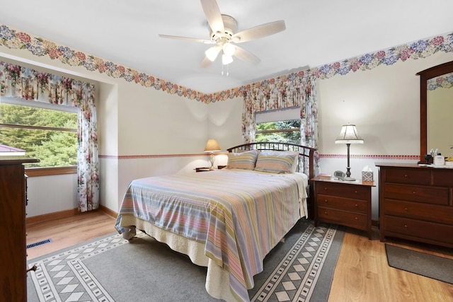 bedroom with visible vents, multiple windows, and light wood-type flooring