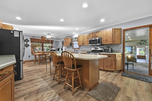 kitchen with light countertops, a breakfast bar area, a healthy amount of sunlight, and appliances with stainless steel finishes