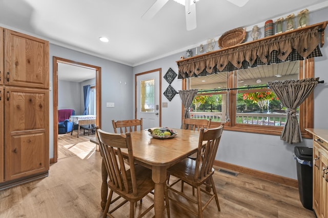 dining room with a ceiling fan, visible vents, light wood-style floors, and baseboards