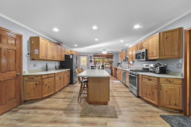 kitchen with a breakfast bar area, a kitchen island, stainless steel appliances, light countertops, and light wood-type flooring