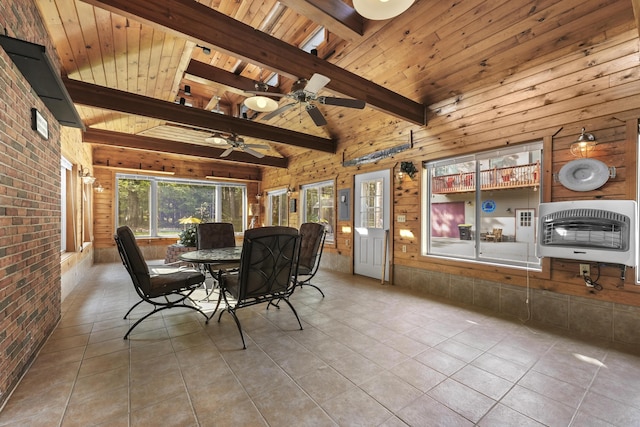 dining space featuring beam ceiling, heating unit, tile patterned floors, and brick wall