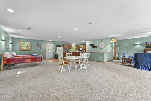 dining space with light carpet, recessed lighting, a textured ceiling, and baseboards