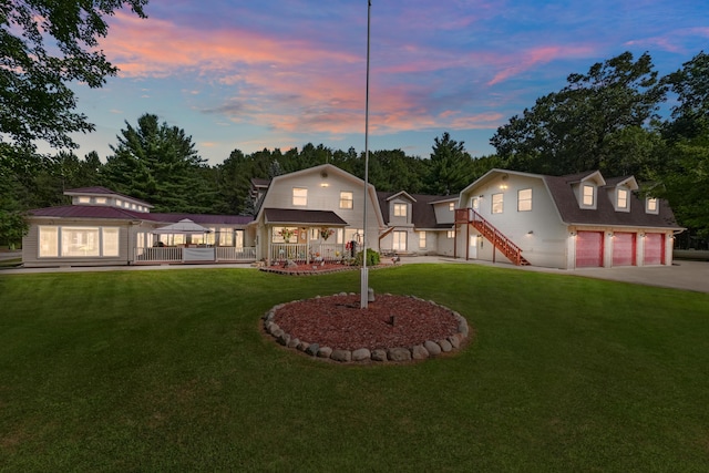 view of front of house with a gambrel roof, driveway, a gazebo, a yard, and stairs