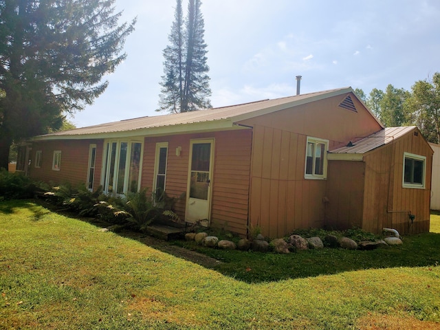 view of home's exterior featuring a yard and metal roof