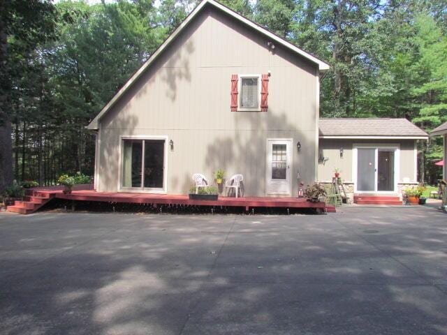 rear view of house with a deck, a patio, and entry steps