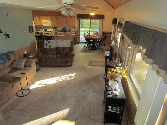 living room featuring light carpet, a ceiling fan, and vaulted ceiling