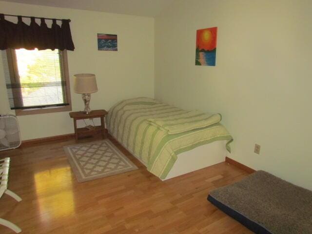 bedroom featuring wood finished floors and baseboards