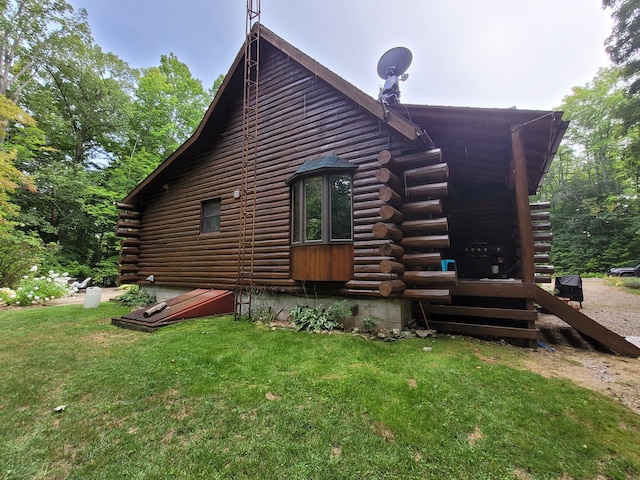 view of side of home featuring log siding and a lawn