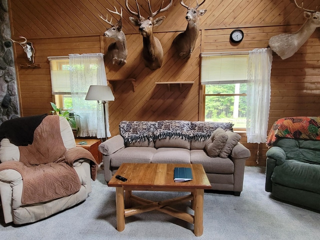 carpeted living room featuring wooden walls