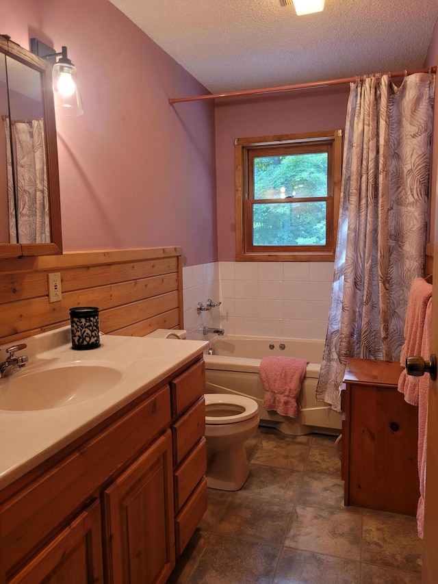 full bath featuring vanity, toilet, shower / bath combo with shower curtain, and a textured ceiling