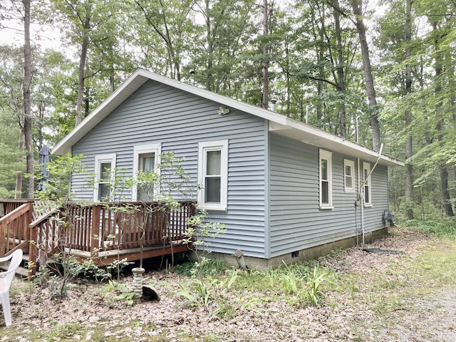 view of property exterior with a deck and crawl space