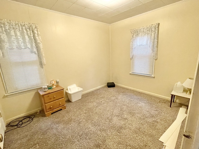 carpeted bedroom featuring crown molding and baseboards