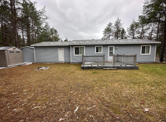 back of property with an outbuilding, a lawn, a storage shed, and a deck