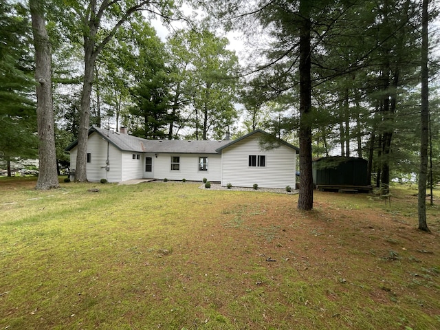 back of house with a lawn and a chimney