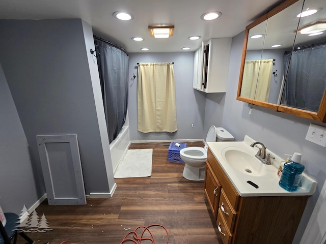 full bath featuring vanity, wood finished floors, baseboards, recessed lighting, and toilet