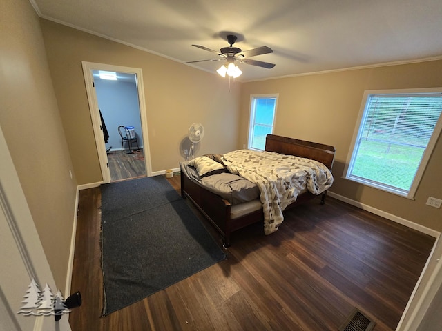 bedroom with visible vents, baseboards, dark wood finished floors, and crown molding