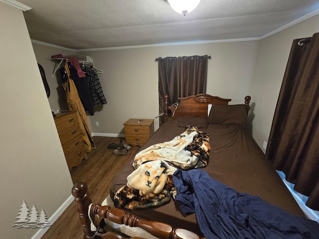 bedroom featuring ornamental molding, baseboards, and wood finished floors