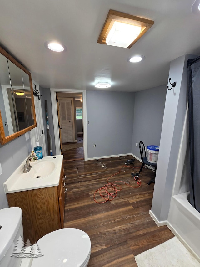 full bathroom with toilet, vanity, baseboards, and wood finished floors