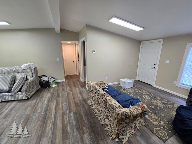 living area featuring lofted ceiling with beams, wood finished floors, and baseboards