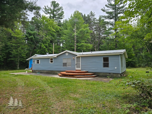 back of house with crawl space, metal roof, and a yard