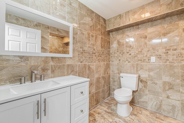 bathroom featuring vanity, tile walls, and toilet