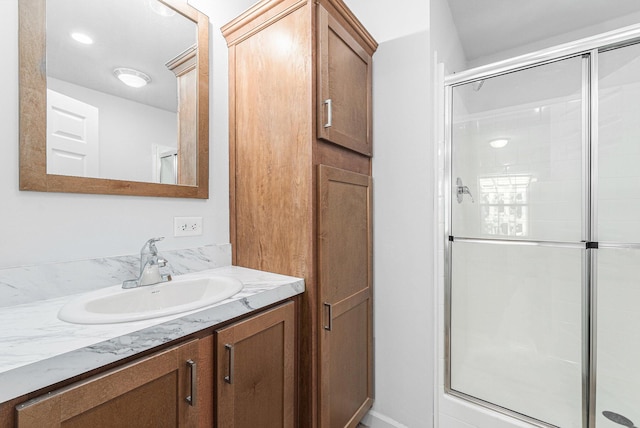 bathroom with a shower stall and vanity