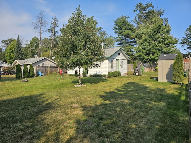 view of yard with an outbuilding, a storage shed, and fence