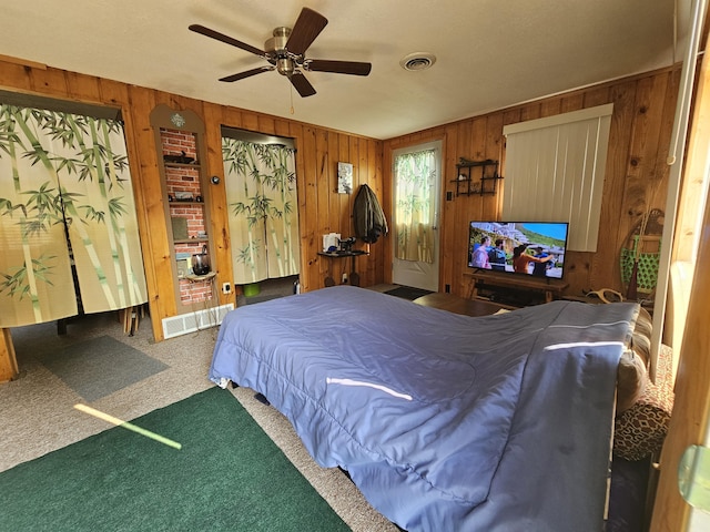 bedroom with visible vents, carpet floors, and wooden walls