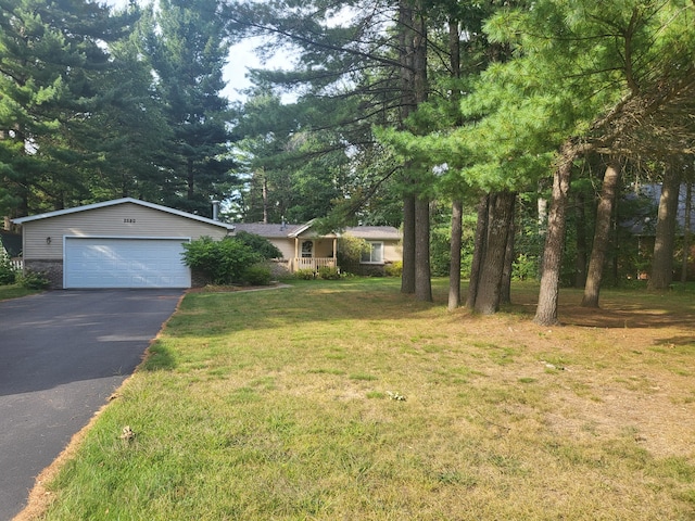 ranch-style home with aphalt driveway, an attached garage, and a front lawn