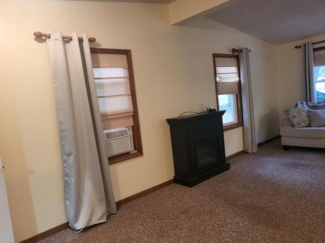 interior space with a glass covered fireplace, baseboards, and carpet floors