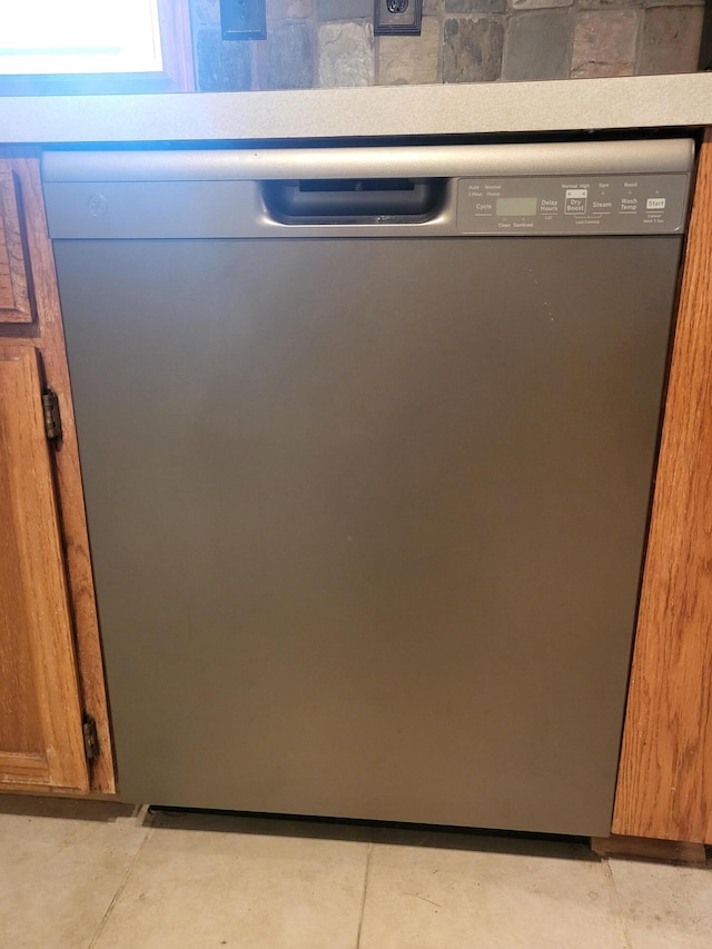 interior details featuring brown cabinetry, concrete floors, and stainless steel dishwasher