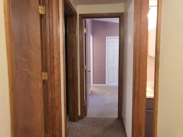 corridor with baseboards and carpet floors