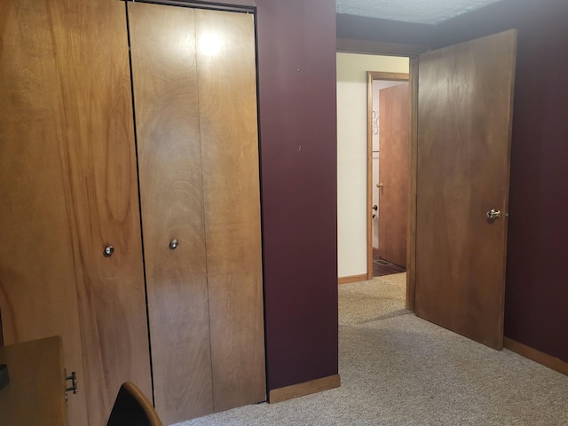 carpeted bedroom featuring a closet and baseboards