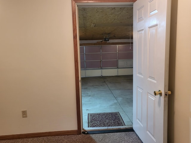 hallway with baseboards and concrete flooring