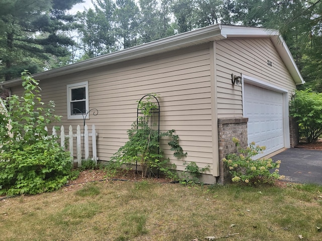 view of property exterior with a detached garage, brick siding, and an outdoor structure