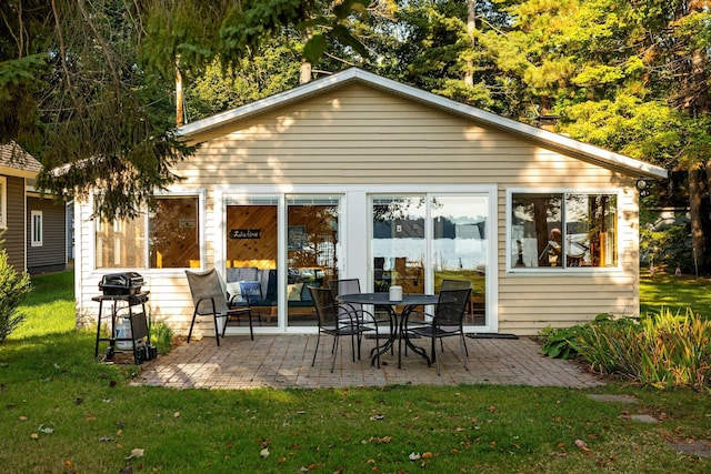 back of property with a lawn and a patio area