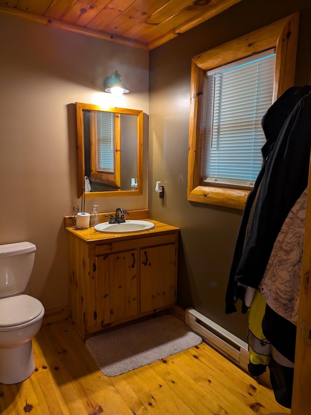 half bathroom with baseboards, wood ceiling, toilet, vanity, and wood-type flooring