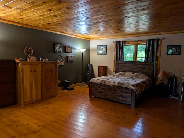 bedroom with crown molding, wood ceiling, light wood-style floors, and baseboards