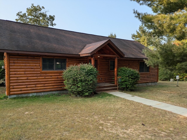 cabin featuring a front lawn, a porch, and roof with shingles