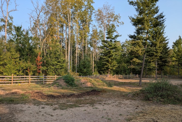 view of yard with fence and a forest view