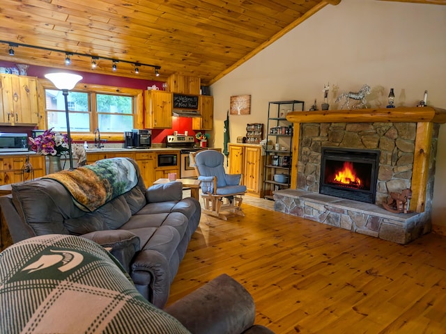 living area with wood ceiling, lofted ceiling, light wood-style floors, and a stone fireplace