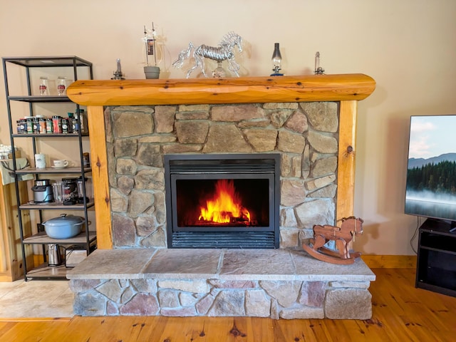 details with baseboards, wood finished floors, and a fireplace