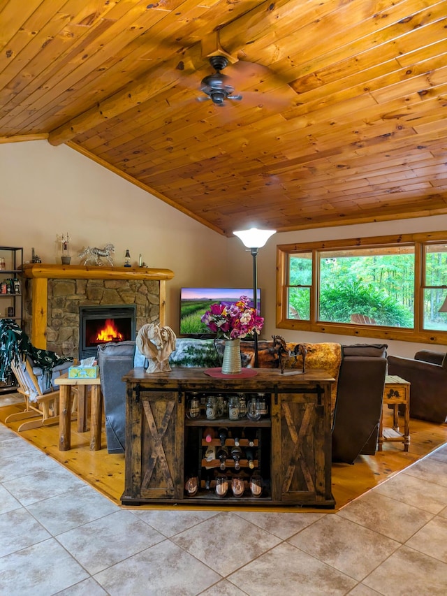 tiled living room with a stone fireplace, lofted ceiling with beams, a ceiling fan, and wooden ceiling