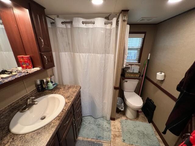 full bath with vanity, curtained shower, toilet, and visible vents